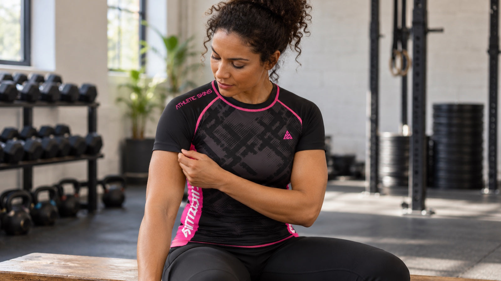 AI-generated editorial illustration of a fictional woman wearing the Athletic Skins Enduro Black/Pink short-sleeve top, looking at its sleeve after training.